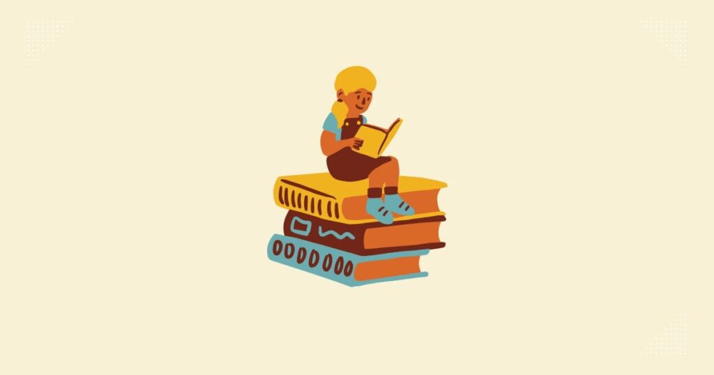 本の上に女の子が座って、本を読んでいる