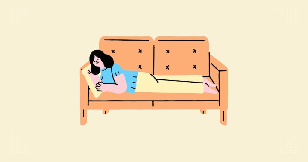 ソファで女性が寝転がってリラックスしている。